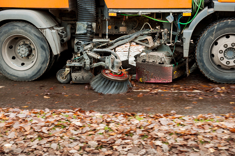 Straßenreinigung im Herbst bei Laubfall mit Kehrmaschine
